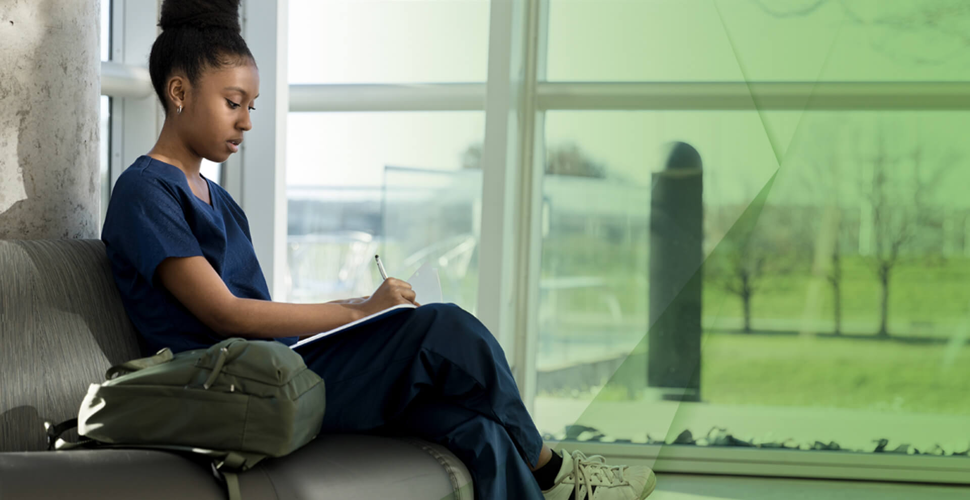 一位年轻的护士坐在长凳上写笔记