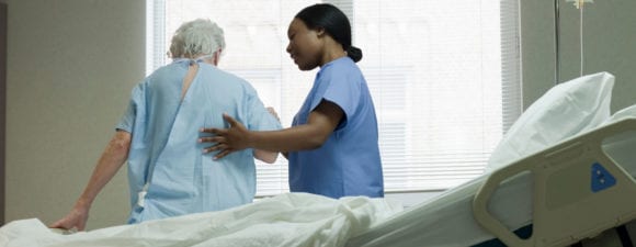 护士在床边帮助老年病人。