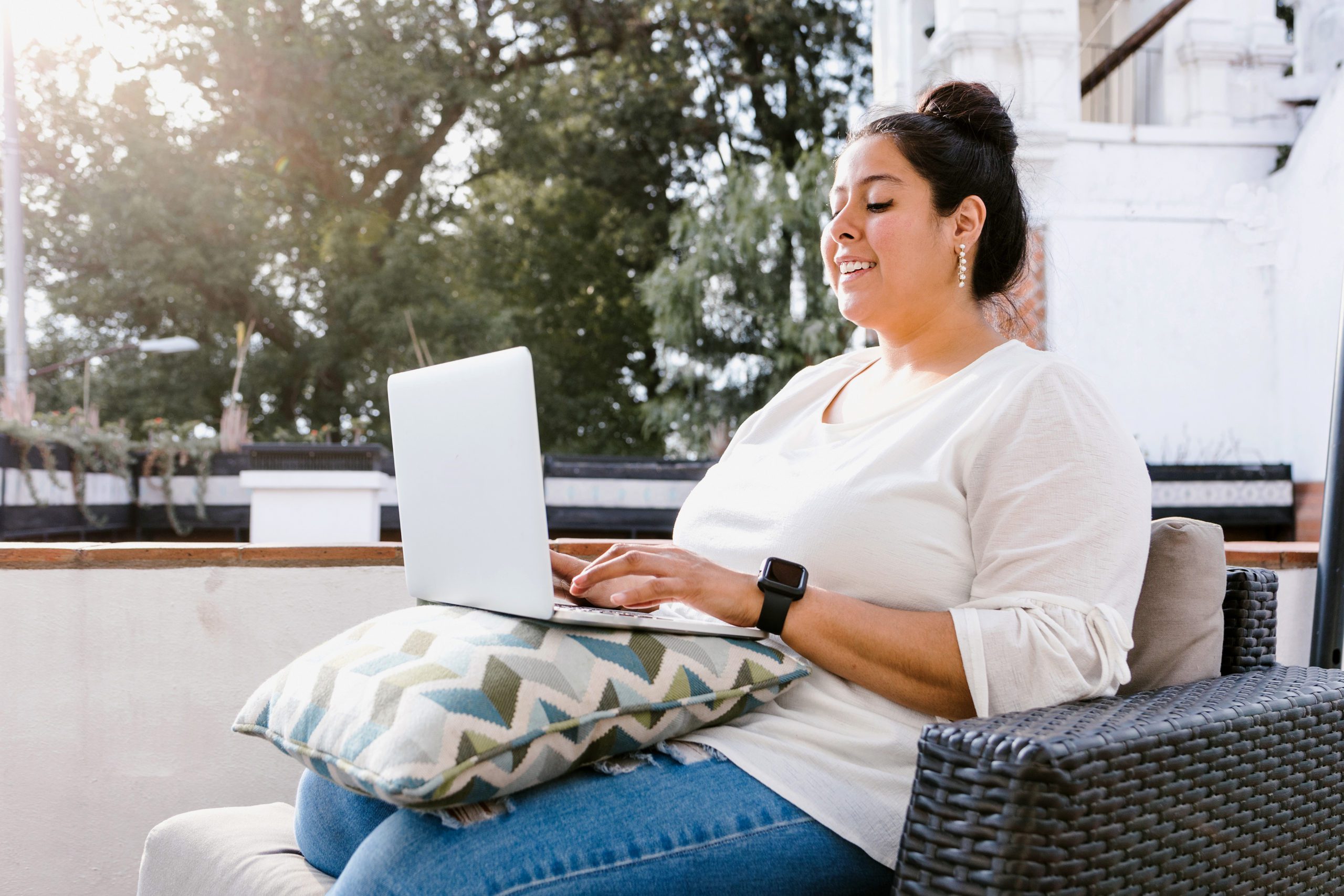 女人坐在外面用笔记本电脑工作